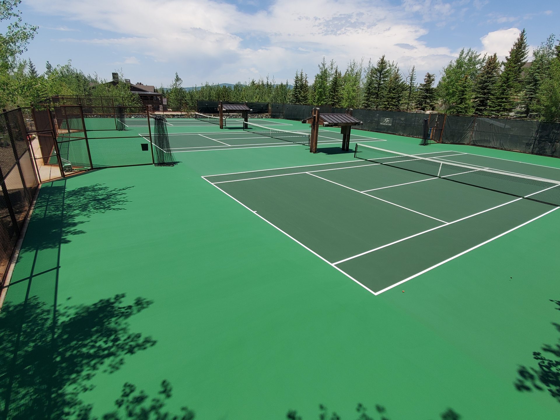 Tennis court complex with mountain forest backdrop