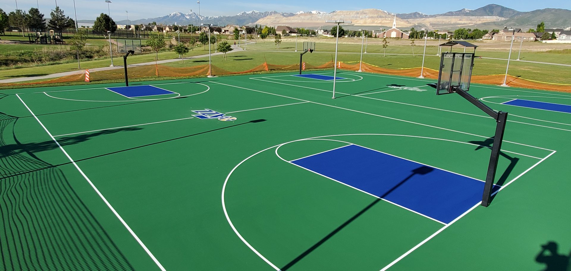 Utah Jazz community court — Jazz logo painted at center court with Wasatch mountain backdrop